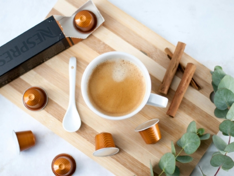 Home Elegant coffee setup with Nespresso capsules, cinnamon, and eucalyptus, perfect for a stylish coffee break.